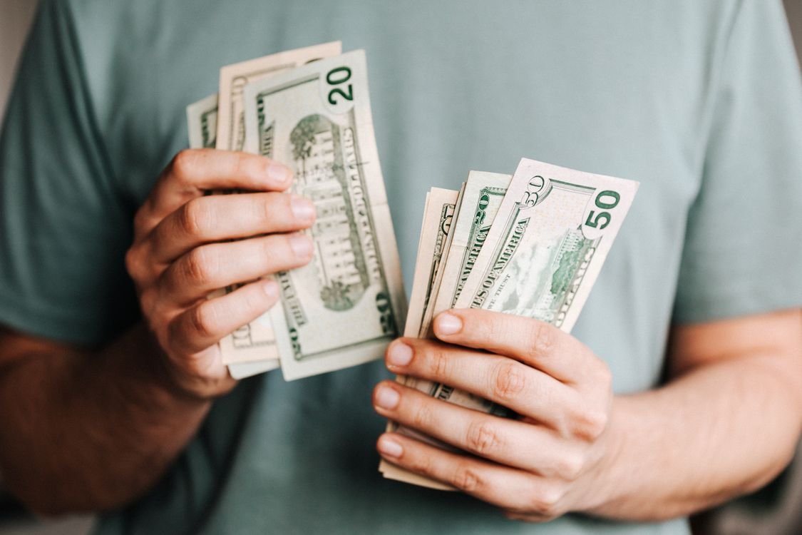 Monthly dividend stocks guide showing coins and money representing passive income for income investors 2026