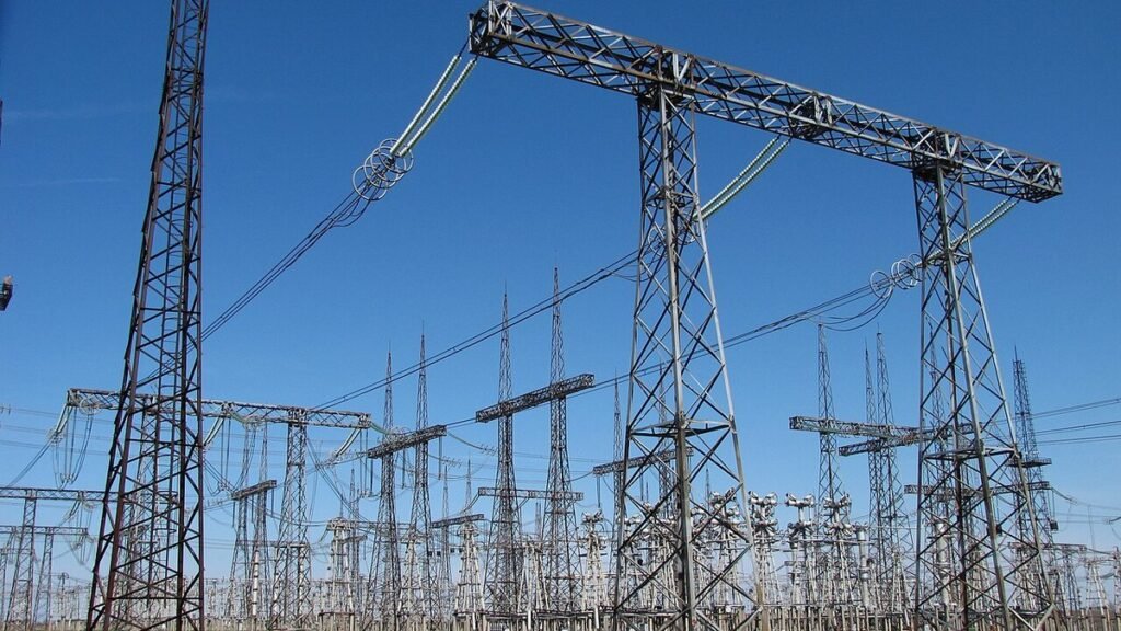 High-voltage switchgear and transmission towers at an electrical substation